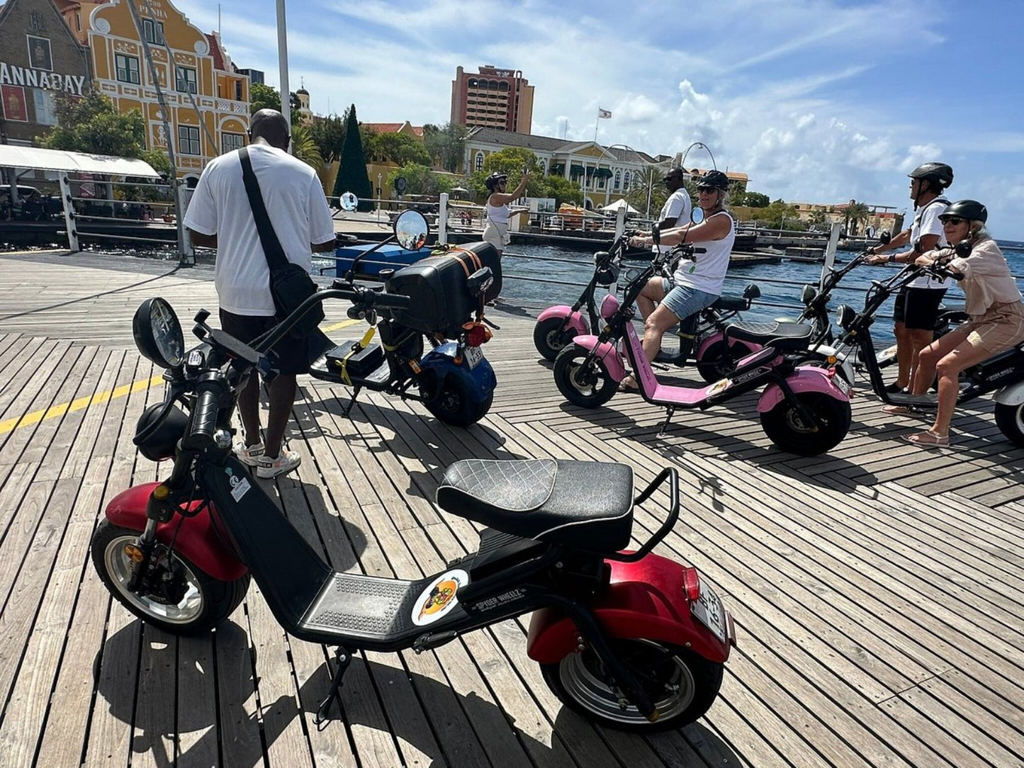 Iguana Ride electric scooters and riders at the waterfront in Willemstad, Curaçao