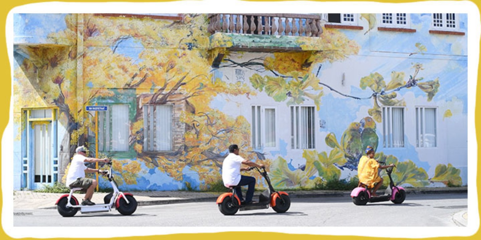 Iguana Ride guests riding electric scooters through Punda in Willemstad, Curaçao