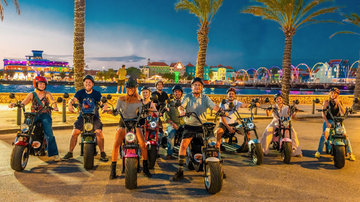 Iguana Ride Curaçao riders by the Willemstad waterfront at dusk